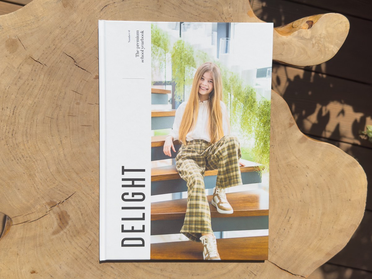 Обкладинка випускного альбому DELIGHT — портрет дівчинки на всю висоту й вертикальний напис DELIGHT